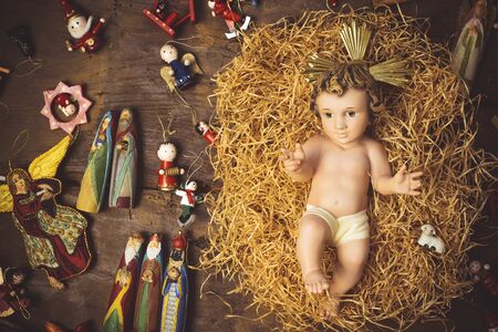 Christmas greeting card, Baby Jesus vintage figurine in his crib and xmas decorations.の写真素材