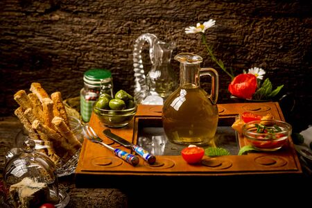 Extra quality virgin olive oil in a glass jar, surrounded by food in a rustic kitchenの写真素材