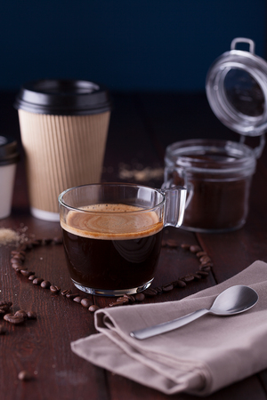 Black coffee among heart shaped coffee beansの写真素材