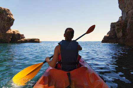 Girl is kayaking on the adriatic seaの写真素材