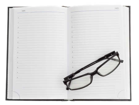 open dayplanner and optical black glasses on the pageの写真素材