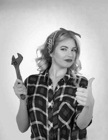 The blonde holds a wrench on a white backgroundの写真素材