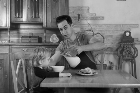 man with little boy in the kitchen preparing a meal. retroの写真素材