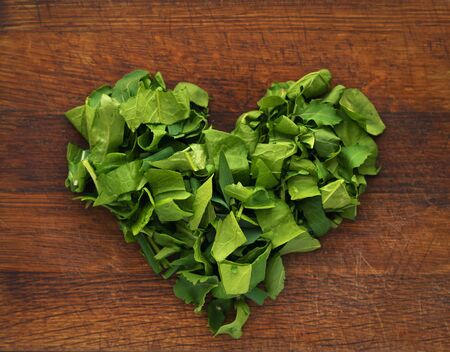 chopped spinach in the form of a heart on a cutting board