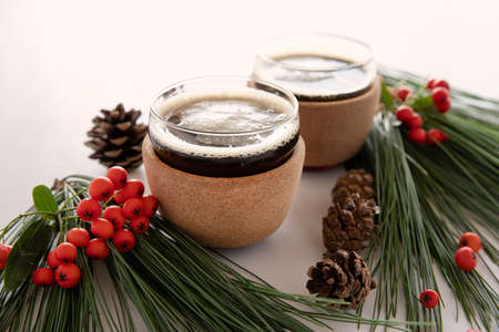 Coffee cup with fir branches and red vegetable balls