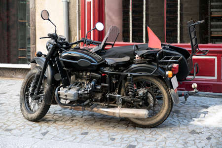 A side-care motorbike parked in a paved street in front of a shopの写真素材