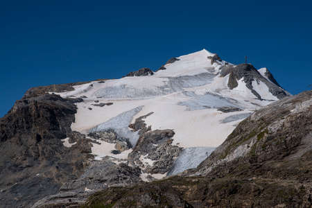 A summer mountain hiker on the summits in front of glaciersの写真素材