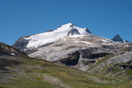 A summer mountain hiker on the summits in front of glaciersの写真素材