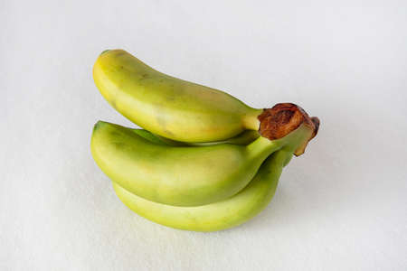 Small yellow and green bananas on a white backgroundの写真素材
