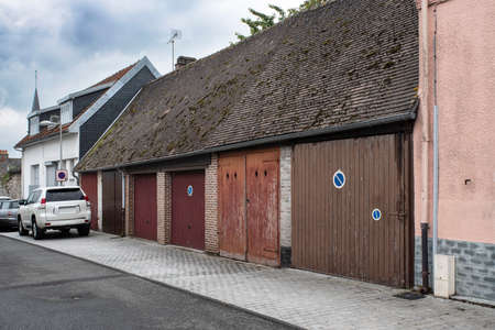 Several individual car garages side by side in a village street in Franceの写真素材