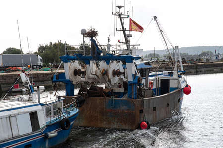 A fishing boat enters the port in Normandy, Franceの写真素材