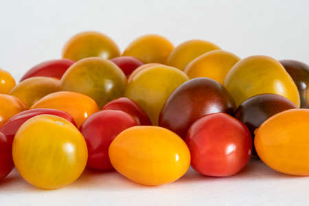 Close-up of a group of cherry tomatoes of different colours, yellow, green, black and redの写真素材