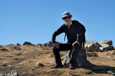A hiker sitting on top of a mountain in the Alps in France in summerの写真素材