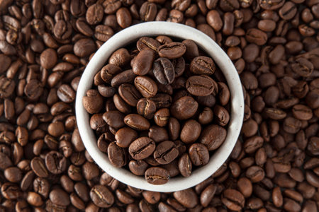 A mug with coffee on a pile of coffee beansの写真素材