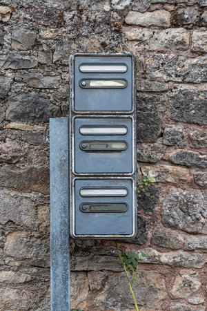 group of old mailboxes against a stone wallの写真素材