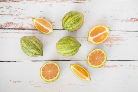 Close-up of pink lemons with stripes on a white wood backgroundの写真素材