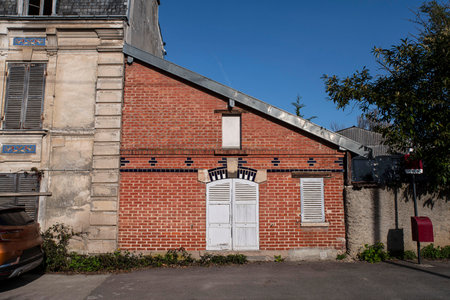 Facade of an old small house in red brick with white wooden shuttersの写真素材