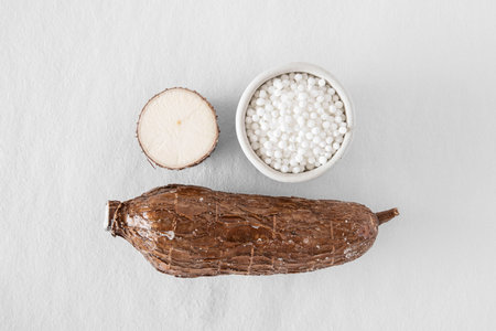 Close-up of a cassava root on a white background with tapioca pearlsの写真素材