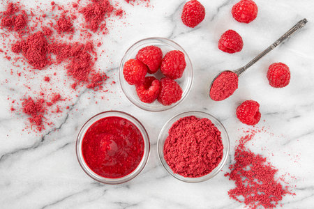 Dehydrated raspberry powder with raspberries on the sideの写真素材
