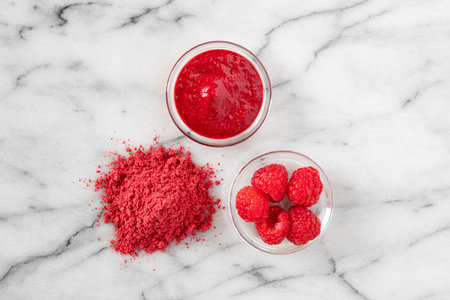 Dehydrated raspberry powder with raspberries on the sideの写真素材