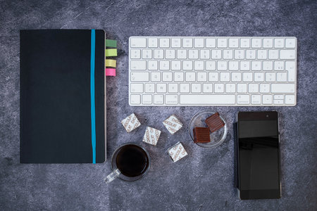 Coffee break with caramels and chocolates on a computer at the office or for leisure. Chocolate is...