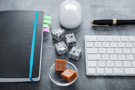 Coffee break with caramels on a computer at the office or for leisure. It is written in French "GuÃ©rande salt" on the small squares of confectioneryの写真素材