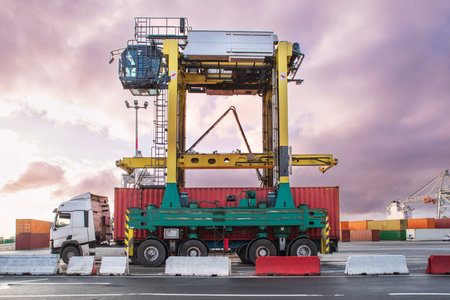 Unloading containers at a commercial port using cranes and trucksの写真素材