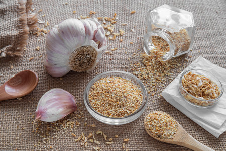 Garlic and garlic seeds in a glass bowl on sackcloth backgroundの写真素材