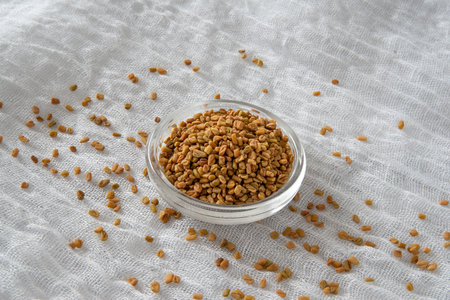 Fenugreek seeds in a glass bowl on a white backgroundの写真素材