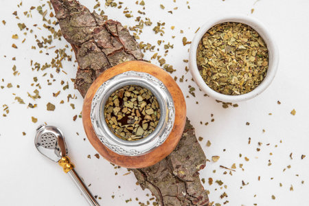 Yerba mate tea in a wooden bowl on a white backgroundの写真素材