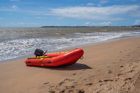Red inflatable boat on a beach in Brittany in summer in Franceの写真素材