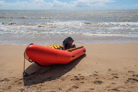 Red inflatable boat on a beach in Brittany in summer in Franceの写真素材