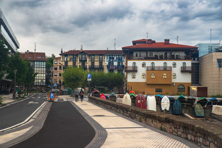 Panorama of the city of Irun in Spain with boats on the quay and two touristsの写真素材