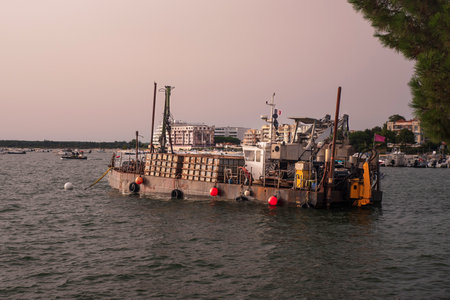 A barge on the sea moored with a crane and worksite equipmentの写真素材