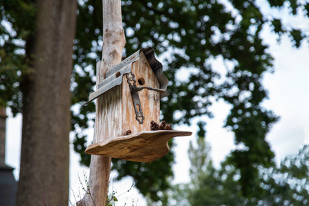 Wooden birdhouse hanging from a tree in a garden or park