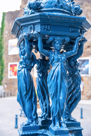 A blue Wallace fountain in a street in the town of Villedieu-les-PoÃªles in Normandy in Franceの写真素材