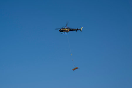 Air transport of materials using a helicopter for a construction siteの写真素材