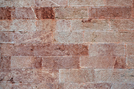 Texture of an old stone wall with a white or slightly rusty tint on certain stonesの写真素材