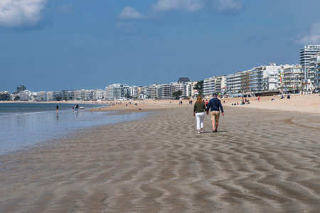 A couple walking on a beach in Brittany in the town of La Bauleの写真素材