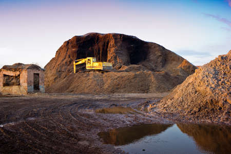 bulldozer on a pile of wood chips in an abandoned factoryの写真素材