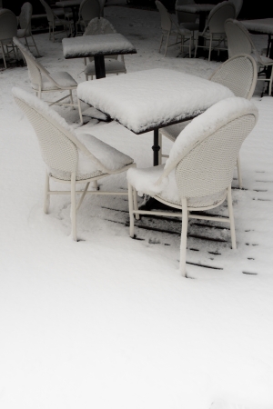 empty table and chairs with pillows of white snowの写真素材