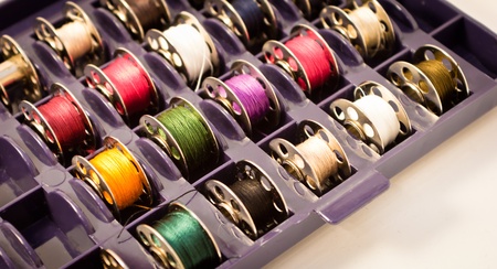 box with several colorful spools for sewing machineの写真素材