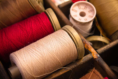 sewing thread in red and white in a wooden box