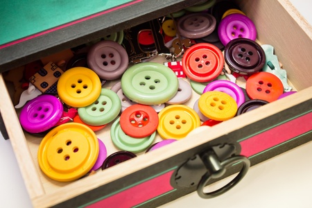 old box full of colorful plastic buttons for sewing