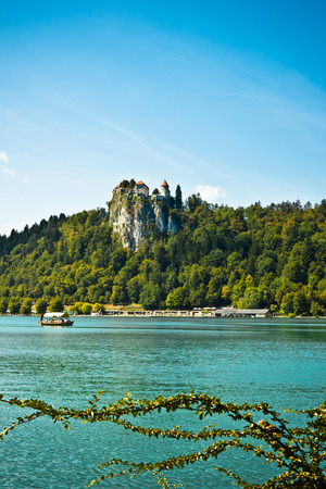 view of the castle from the shore of lake bled with boat horizontalのeditorial素材