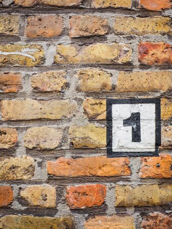 Civic number one on a brick wall in brugesの写真素材