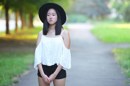 female hat nature summer sun sunset looks pleased. azitka woman black hair dancing around trees.の写真素材