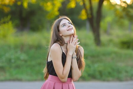 Woman with long hair and beautiful eyes on a green background shows the different human emotions. Lady portrays happy wishesの写真素材