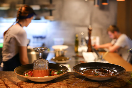 Girl female woman chef prepares dishes in the restaurant, pours into a bowl, gloved hands, a kitchen...
