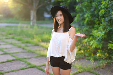 female hat nature summer sun sunset looks pleased. azitka woman black hair dancing around the trees looking at the camera. portrait.の写真素材